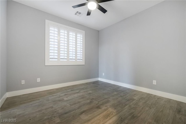 spare room featuring ceiling fan, dark wood-type flooring, visible vents, and baseboards