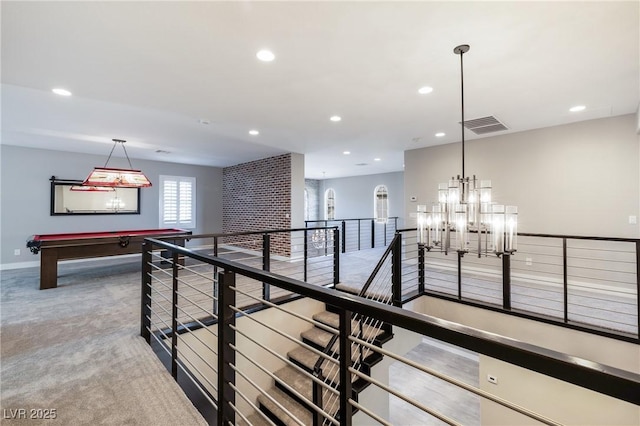 hallway featuring a chandelier, recessed lighting, carpet floors, visible vents, and an upstairs landing