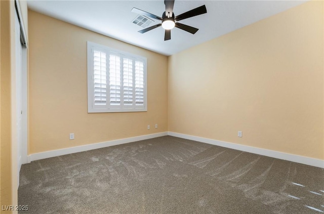 empty room featuring a ceiling fan, dark colored carpet, visible vents, and baseboards