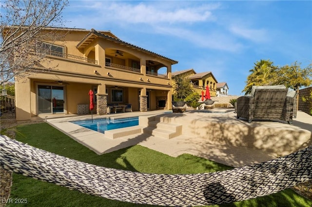 back of property featuring a fenced backyard, ceiling fan, a balcony, and a patio