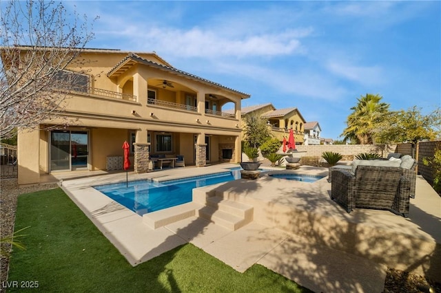 back of house featuring ceiling fan, a fenced backyard, a balcony, stucco siding, and a patio area