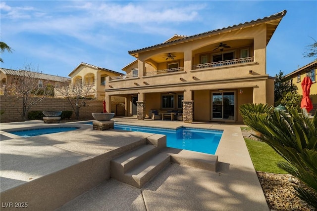 back of house featuring ceiling fan, a balcony, fence, stucco siding, and a patio area