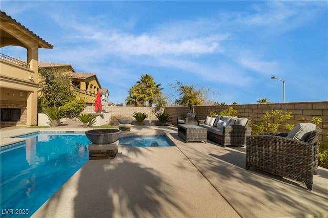 view of swimming pool with a fenced in pool, a fenced backyard, a patio, and an outdoor living space with a fireplace