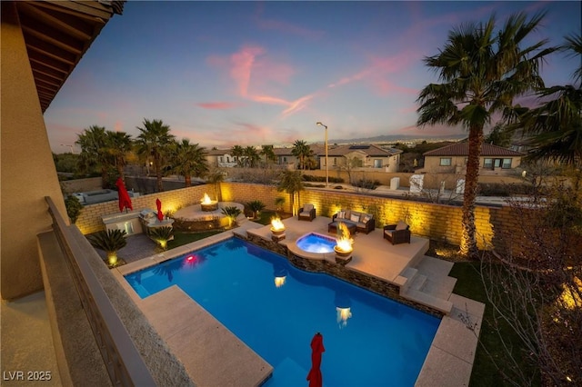 pool at dusk with a fire pit, a patio area, and a fenced in pool