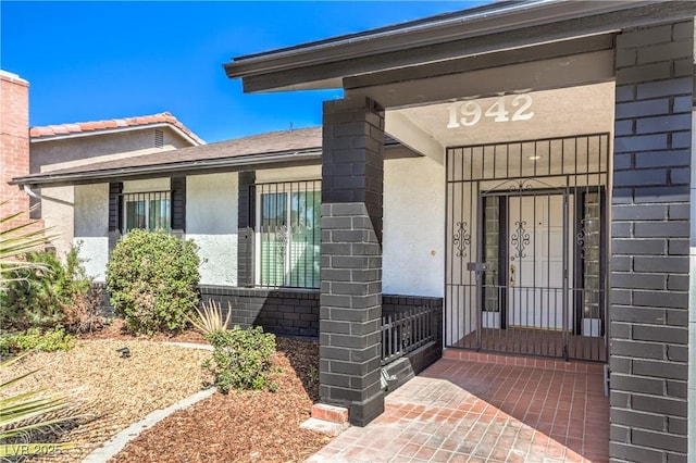 property entrance featuring stucco siding and brick siding