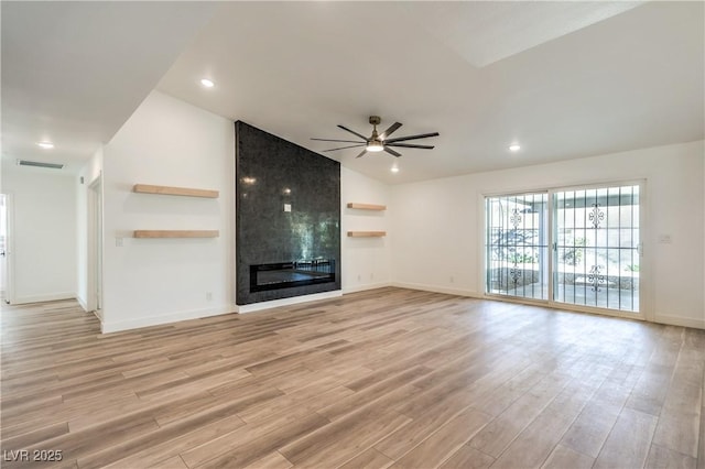 unfurnished living room featuring visible vents, a ceiling fan, vaulted ceiling, light wood-type flooring, and a fireplace