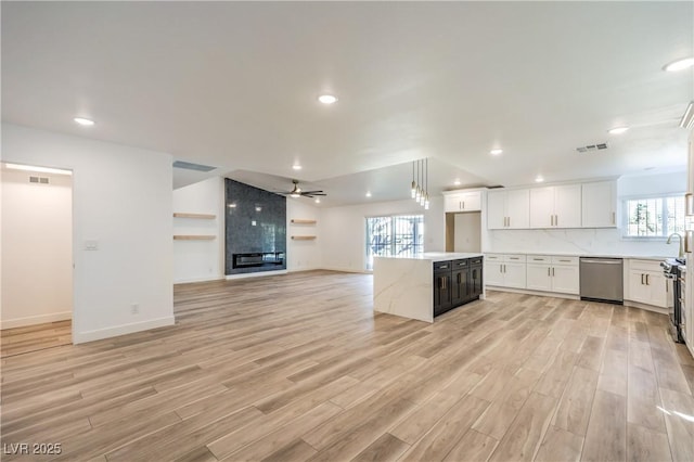 kitchen featuring a kitchen island, white cabinets, open floor plan, light wood-type flooring, and dishwasher