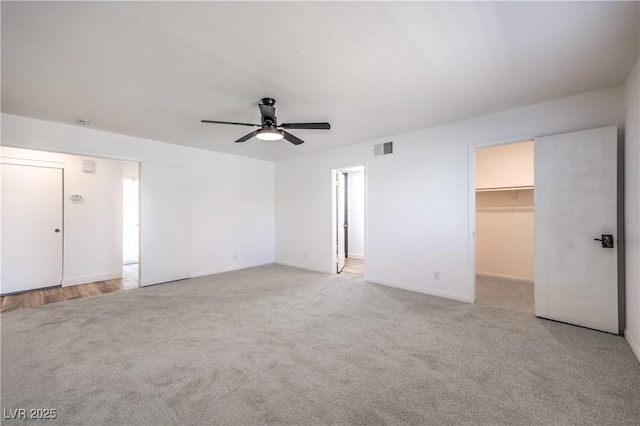 interior space with light carpet, visible vents, and a ceiling fan