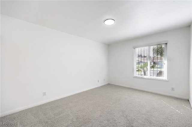 carpeted spare room featuring baseboards