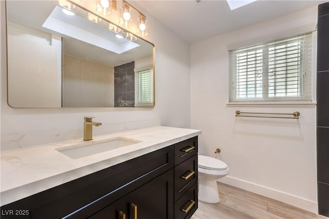 full bathroom featuring baseboards, vanity, toilet, and wood finished floors