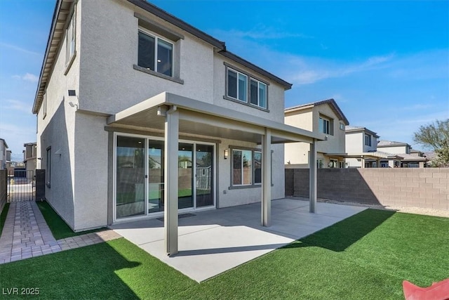 back of house with a patio area, a fenced backyard, a lawn, and stucco siding