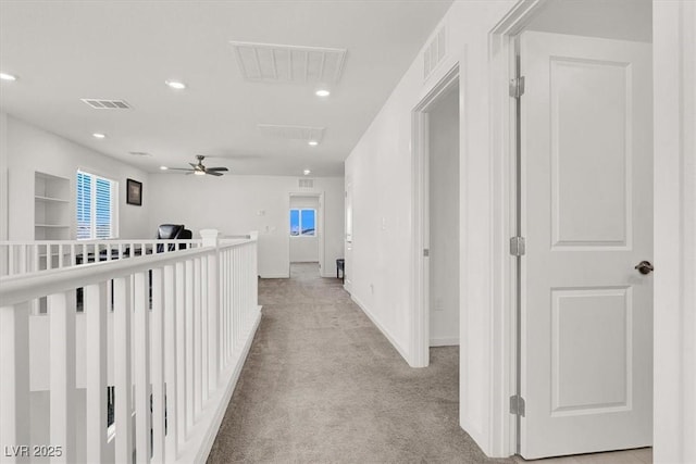 hall with recessed lighting, visible vents, baseboards, and light colored carpet