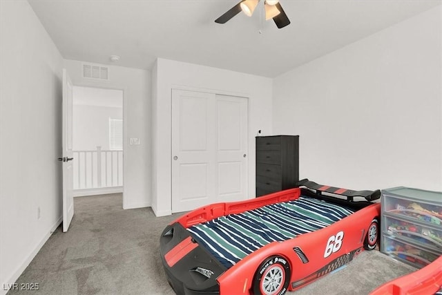 bedroom featuring baseboards, visible vents, a ceiling fan, light colored carpet, and a closet