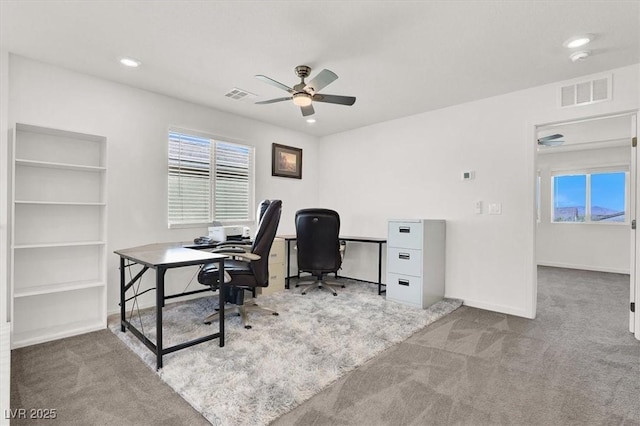 home office featuring light carpet, plenty of natural light, and visible vents