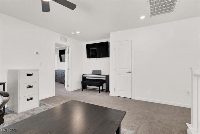 living area with baseboards, a ceiling fan, visible vents, and light colored carpet