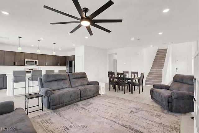 living area with light tile patterned floors, stairway, a ceiling fan, and recessed lighting