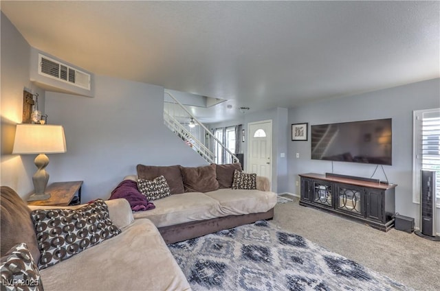 living room with carpet floors, visible vents, plenty of natural light, and stairway