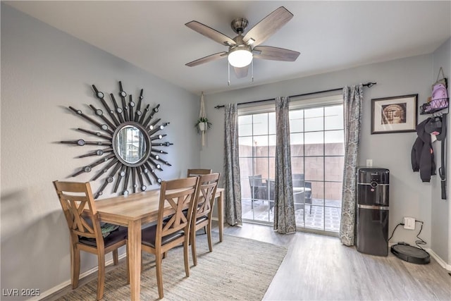 dining area featuring a ceiling fan, light wood-type flooring, and baseboards