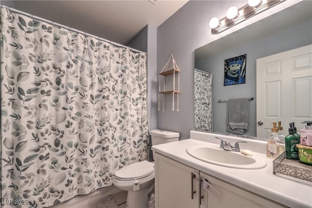 bathroom featuring curtained shower, vanity, and toilet