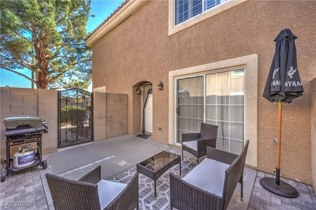 view of patio with a grill and fence