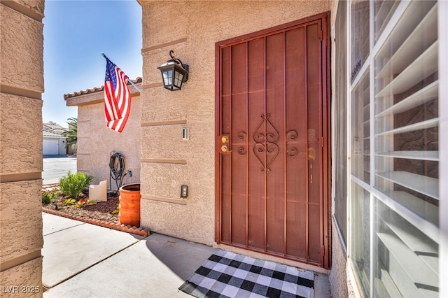 doorway to property featuring stucco siding