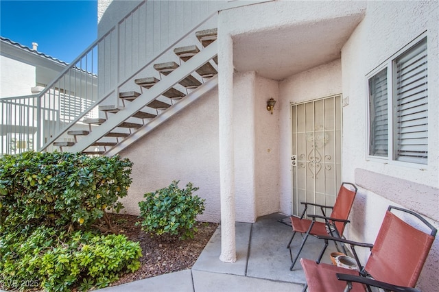 entrance to property featuring stucco siding