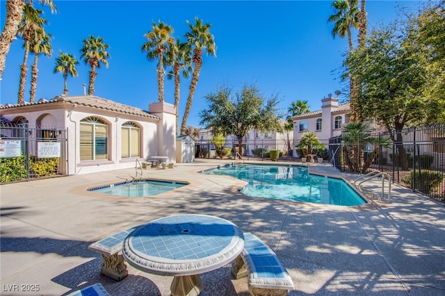 pool featuring a patio area, fence, and a hot tub