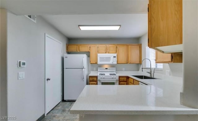 kitchen featuring white appliances, visible vents, light countertops, light brown cabinets, and a sink