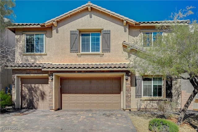 view of front of home with a garage, stone siding, and stucco siding