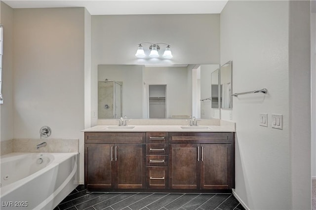 full bath with a sink, a stall shower, a bath, and double vanity