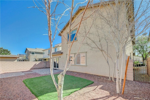 exterior space featuring stucco siding, a patio, and fence