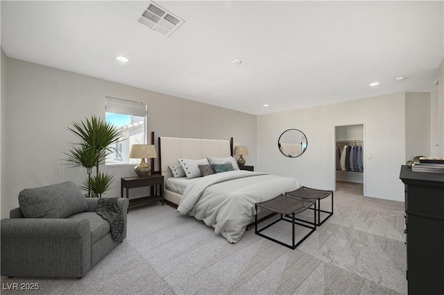 bedroom with visible vents, a walk in closet, light carpet, recessed lighting, and a closet