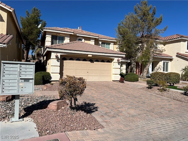 mediterranean / spanish home with stucco siding, a tiled roof, decorative driveway, and a garage