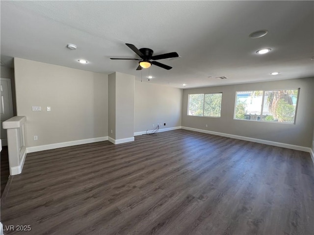 unfurnished living room with recessed lighting, dark wood-style flooring, a ceiling fan, visible vents, and baseboards