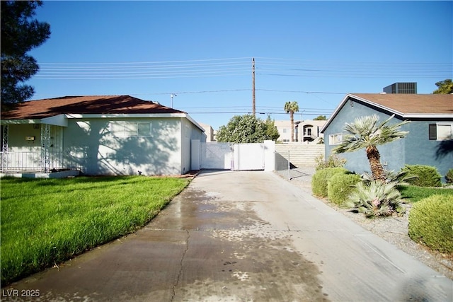 view of property exterior featuring a yard, a gate, fence, and stucco siding