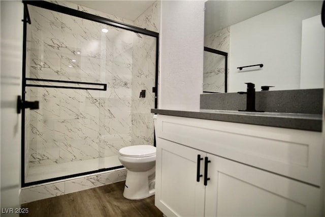 full bathroom featuring vanity, wood finished floors, a marble finish shower, and toilet