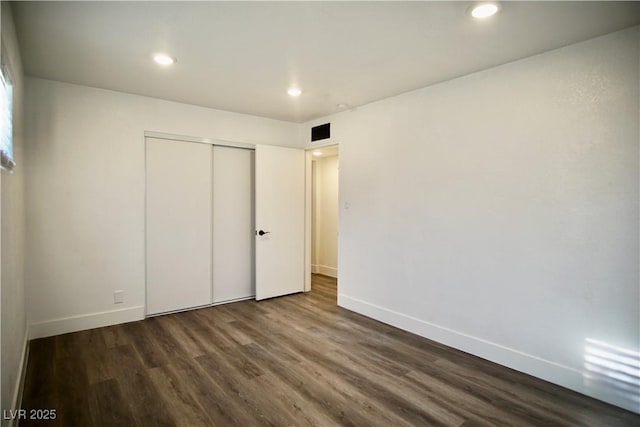 unfurnished bedroom featuring visible vents, baseboards, dark wood-type flooring, a closet, and recessed lighting