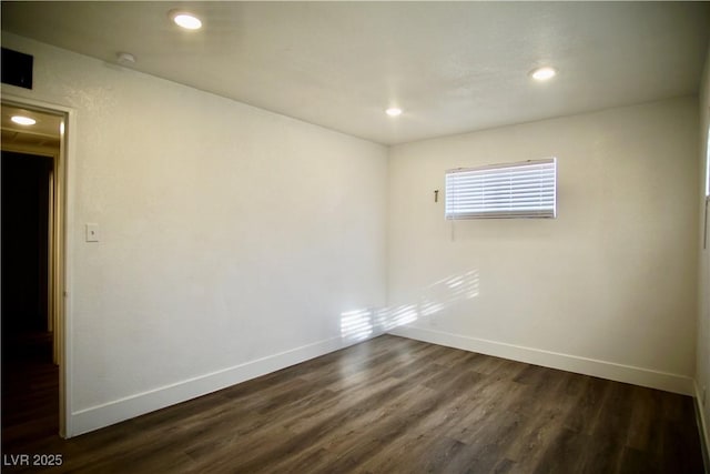 spare room featuring recessed lighting, dark wood finished floors, and baseboards