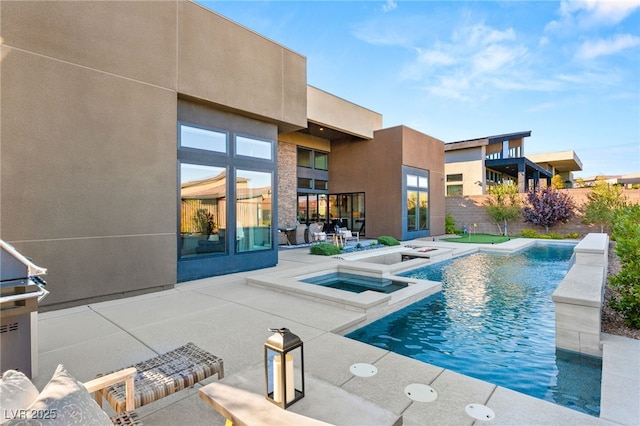 view of swimming pool with a patio area, a pool with connected hot tub, and fence