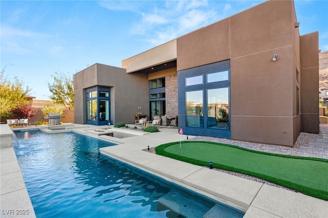 back of property with a hot tub, a fenced in pool, french doors, a patio area, and stucco siding