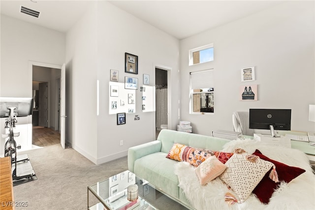 living room with baseboards, visible vents, and light colored carpet