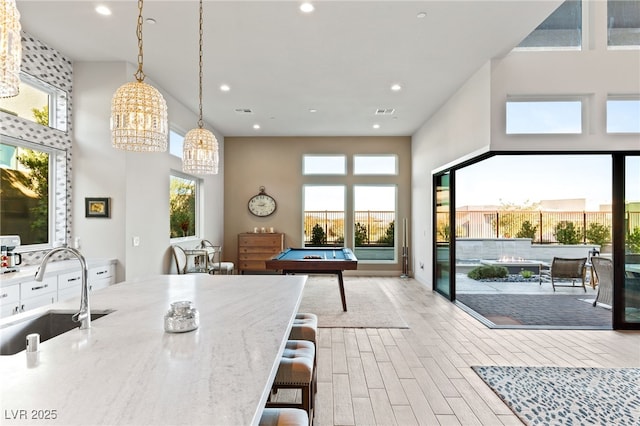 kitchen with open floor plan, wood finished floors, a sink, and a wealth of natural light