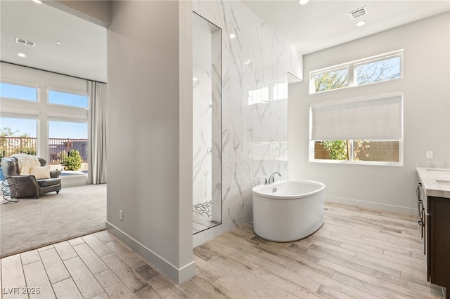 full bath with a marble finish shower, visible vents, and a wealth of natural light