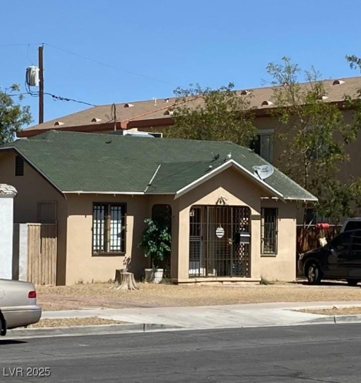 view of front of house featuring fence and stucco siding