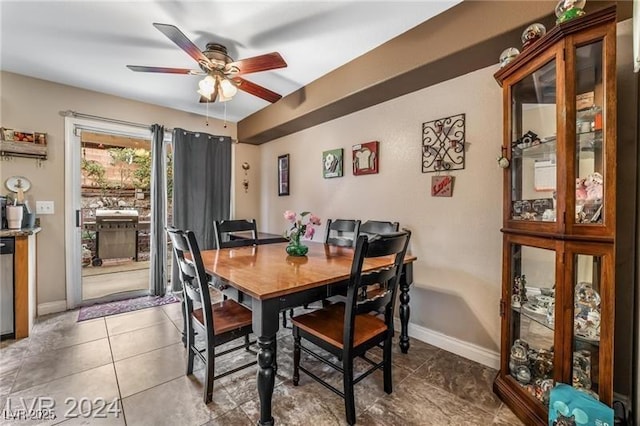 tiled dining room with ceiling fan and baseboards