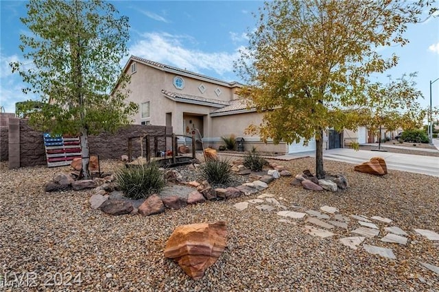 mediterranean / spanish home featuring driveway, a tile roof, fence, and stucco siding