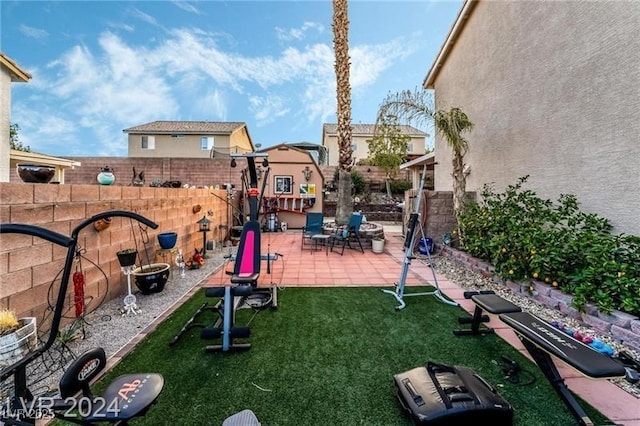 view of jungle gym featuring a yard, a fenced backyard, and a patio