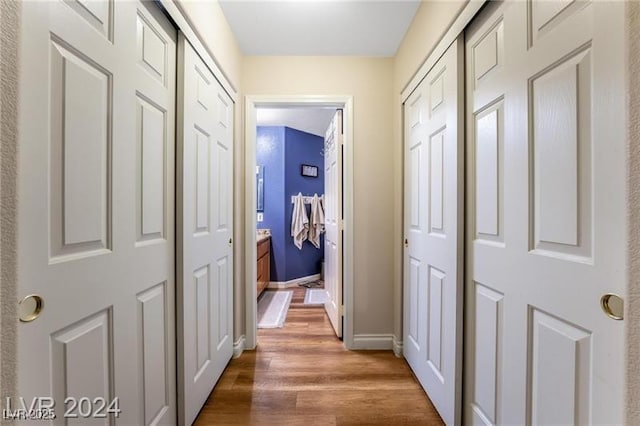 hallway featuring baseboards and wood finished floors