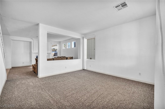 spare room with carpet floors, visible vents, and baseboards