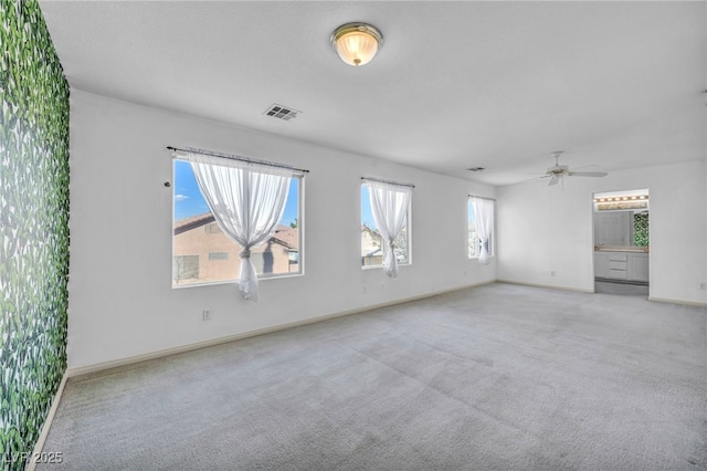 spare room featuring a ceiling fan, baseboards, visible vents, and carpet flooring